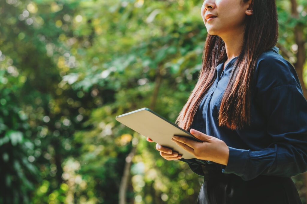 Business Woman using tablet to 2024 analyze ESG concept ,Sustainable development goal (SDGs) Ideas Globe Glass energy-based green business can limit climate change and global warming.